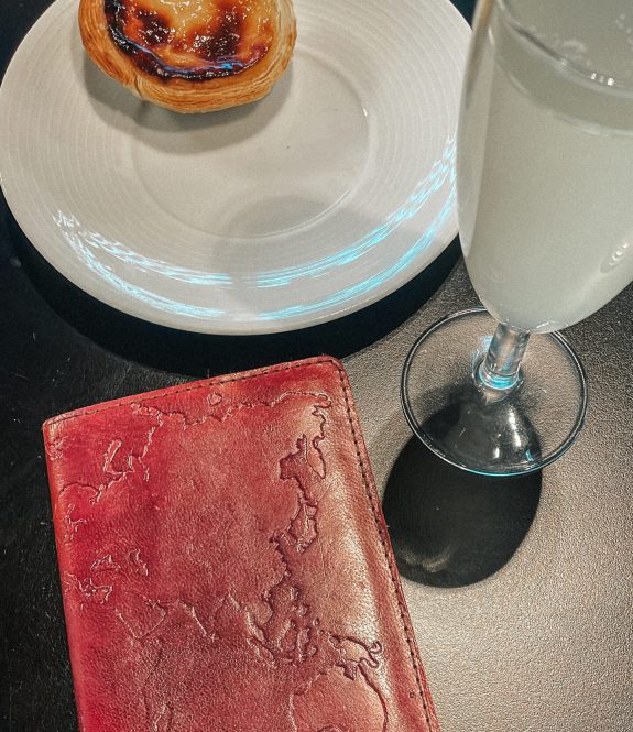 Passport and traditional Portuguese pastel de nata pastry with a refreshing drink at an airport, capturing the essence of Europe travel and the thrill of international travel. Perfect start to a Portugal travel journey